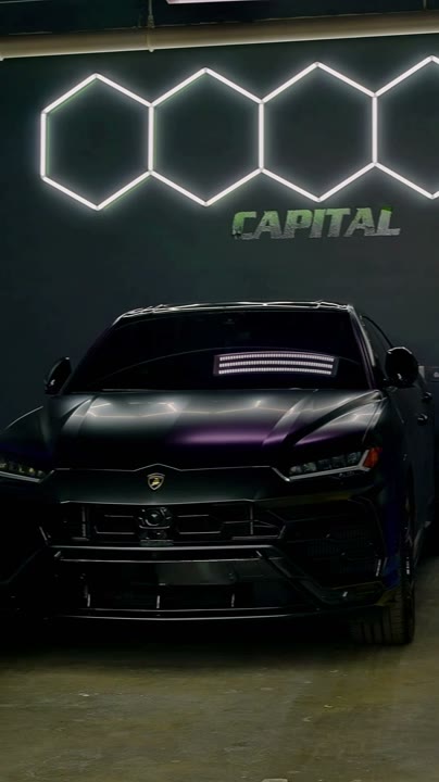 Inside the Capital Collision shop: an SUV parked beneath hexagon lights